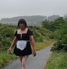 Femme de ménage travestie dans une voie publique sous wheezles pluie